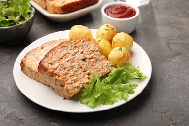 Photo of Delicious baked turkey meatloaf with potatoes served on grey table, closeup