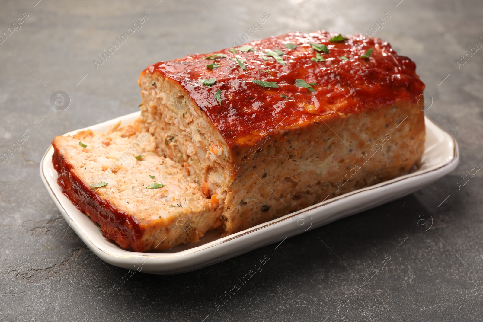 Photo of Delicious baked turkey meatloaf on grey table, closeup