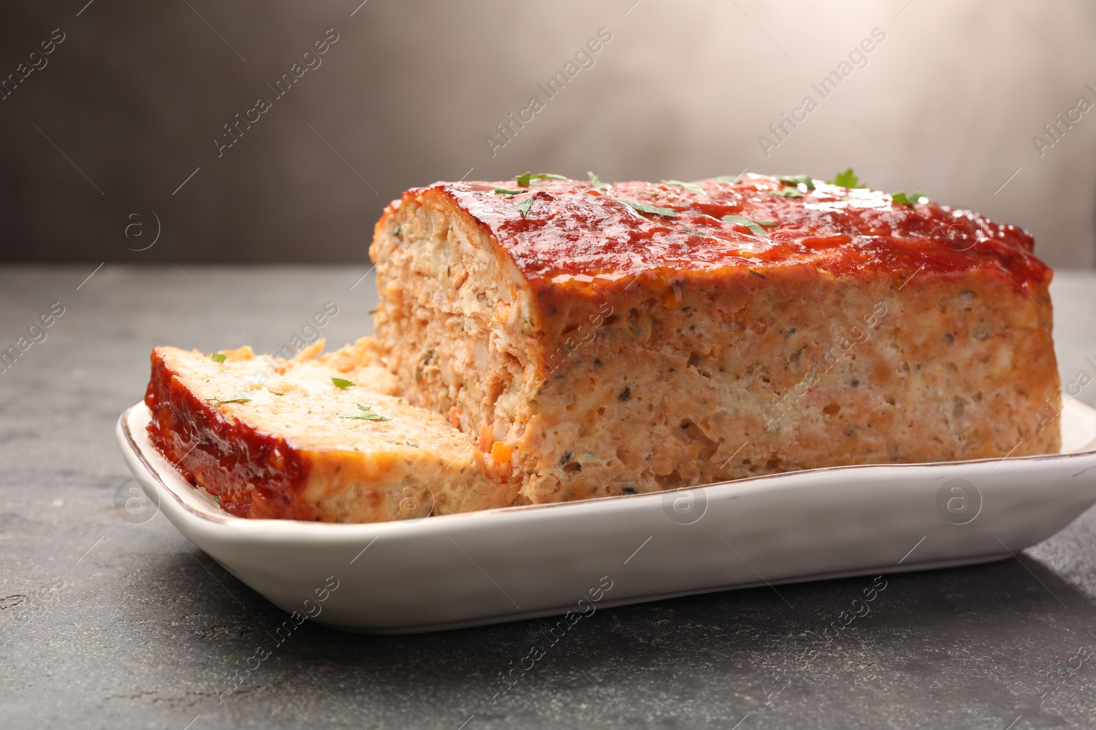 Photo of Delicious baked turkey meatloaf on grey table, closeup