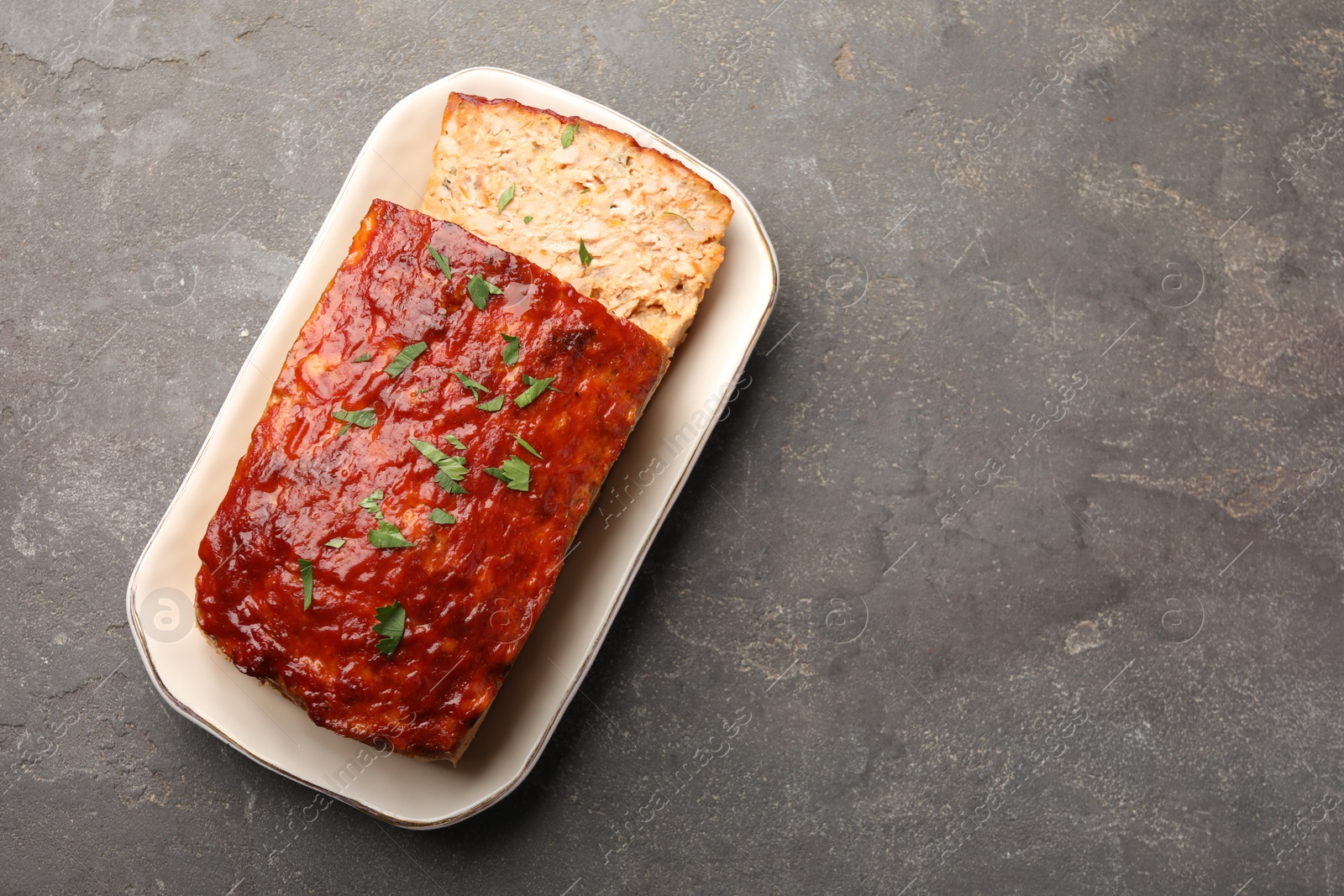 Photo of Delicious baked turkey meatloaf on grey table, top view. Space for text