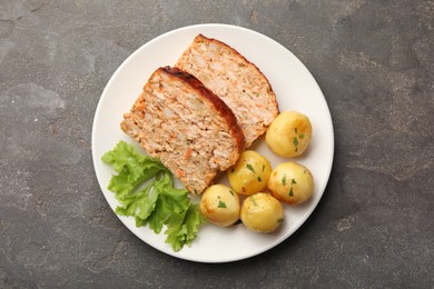 Photo of Delicious baked turkey meatloaf, potatoes and lettuce on grey table, top view