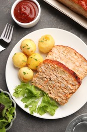 Delicious baked turkey meatloaf with vegetables served on grey table, flat lay