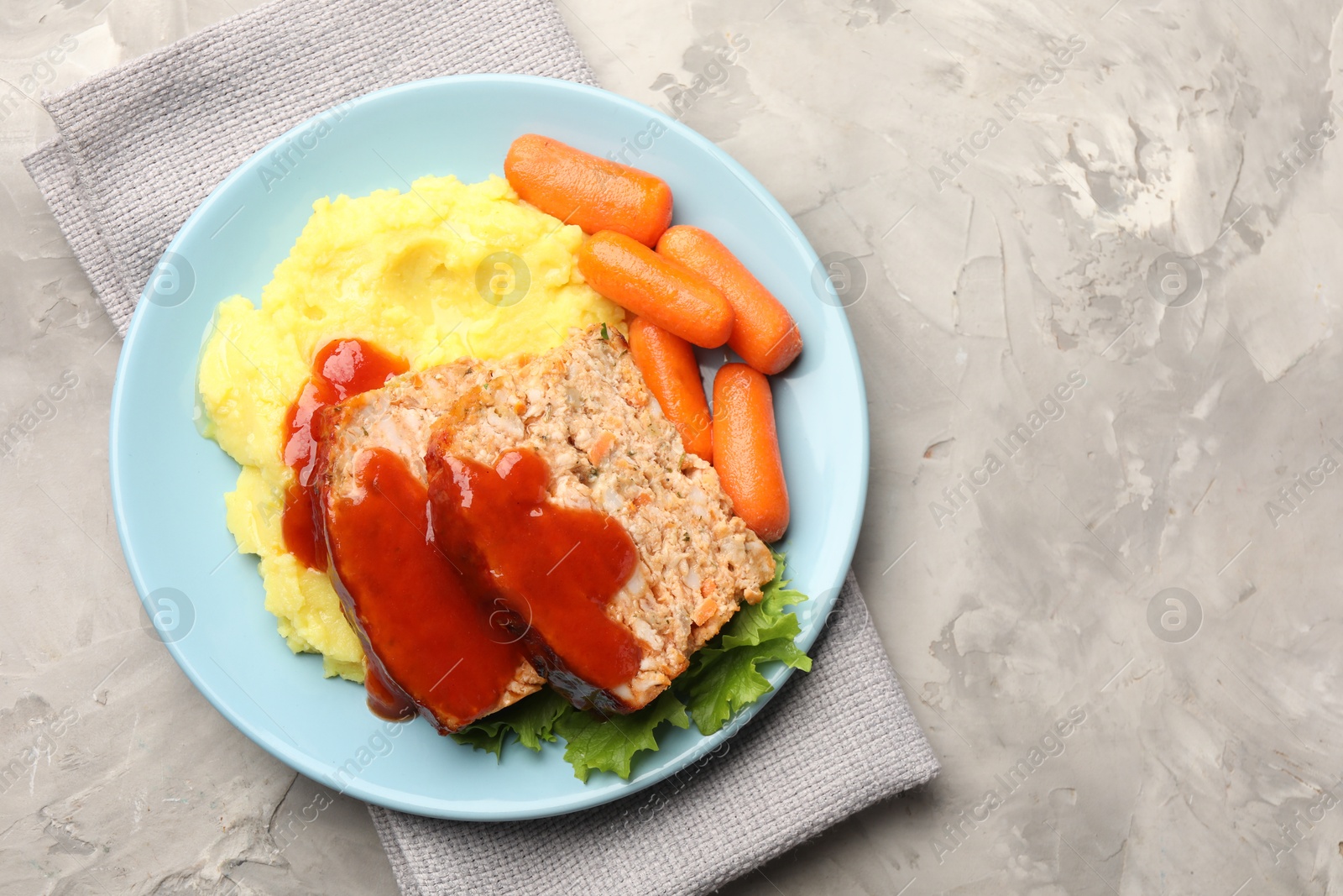 Photo of Delicious baked turkey meatloaf with mashed potato served on grey table, top view. Space for text