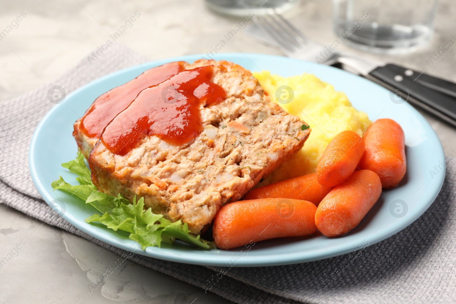 Photo of Delicious baked turkey meatloaf with mashed potato served on grey table, closeup