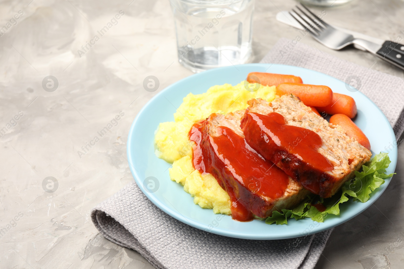 Photo of Delicious baked turkey meatloaf with mashed potato served on grey table, closeup. Space for text