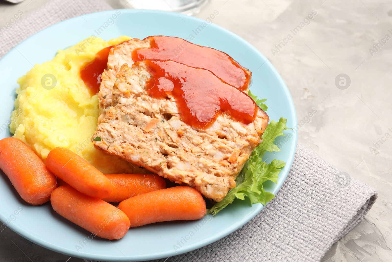 Photo of Delicious baked turkey meatloaf with mashed potato served on grey table, closeup