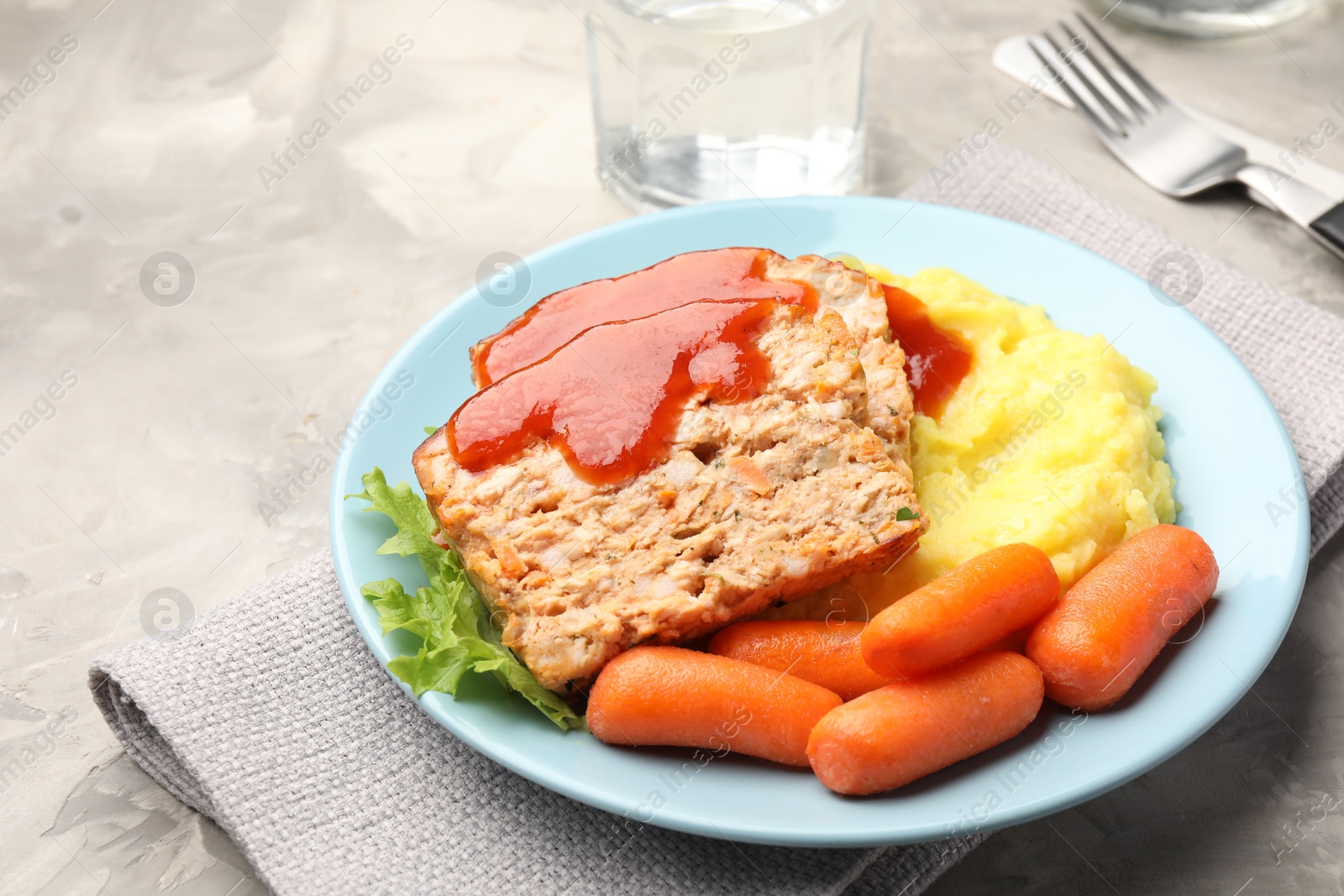 Photo of Delicious baked turkey meatloaf with mashed potato served on grey table, closeup