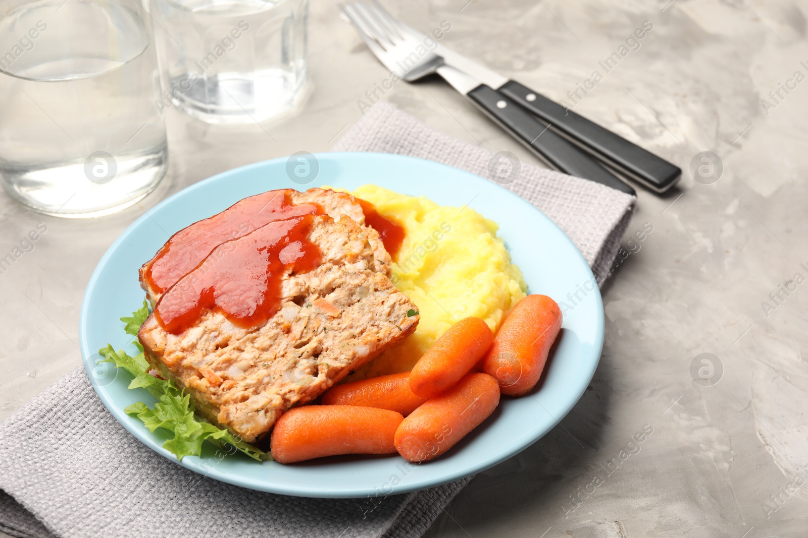 Photo of Delicious baked turkey meatloaf with mashed potato served on grey table, closeup. Space for text