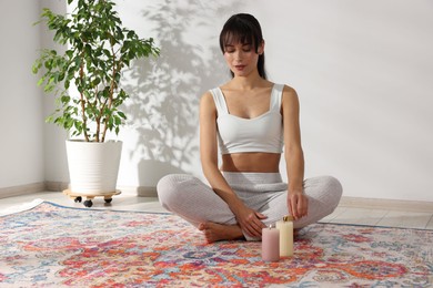 Photo of Woman lighting palo santo stick on floor at home