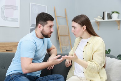 Photo of Resentful couple arguing on couch at home. Relationship problem