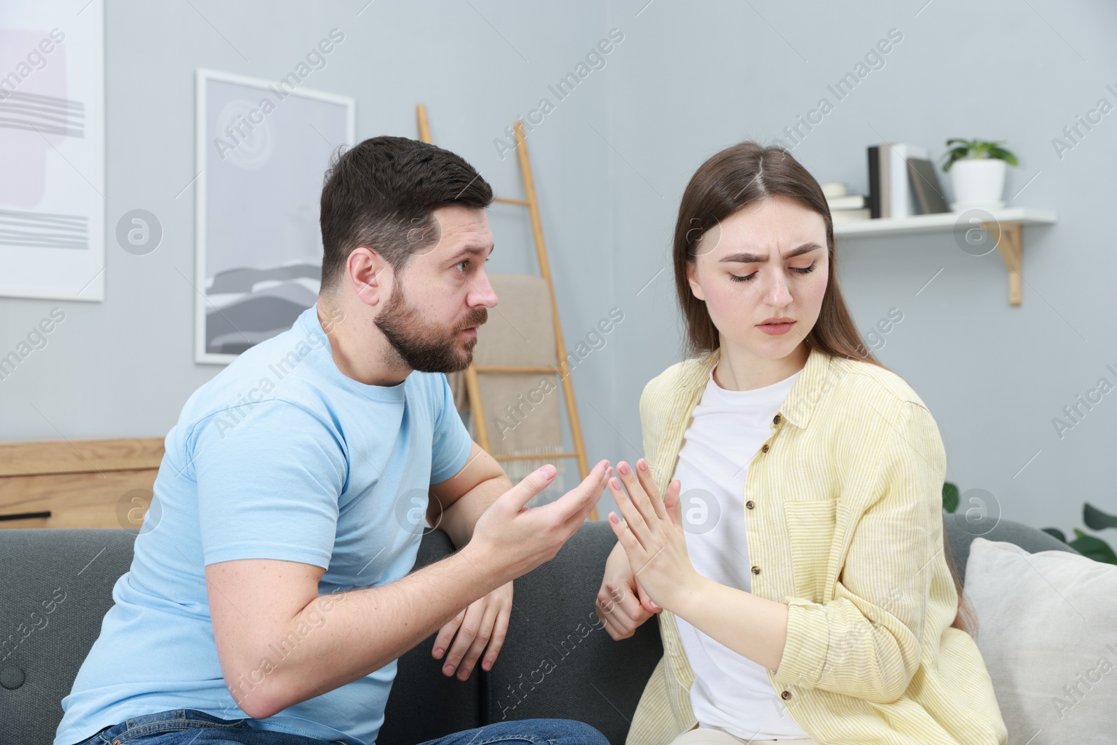 Photo of Resentful couple arguing on couch at home. Relationship problem