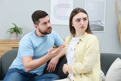 Photo of Resentful couple arguing on couch at home. Relationship problem