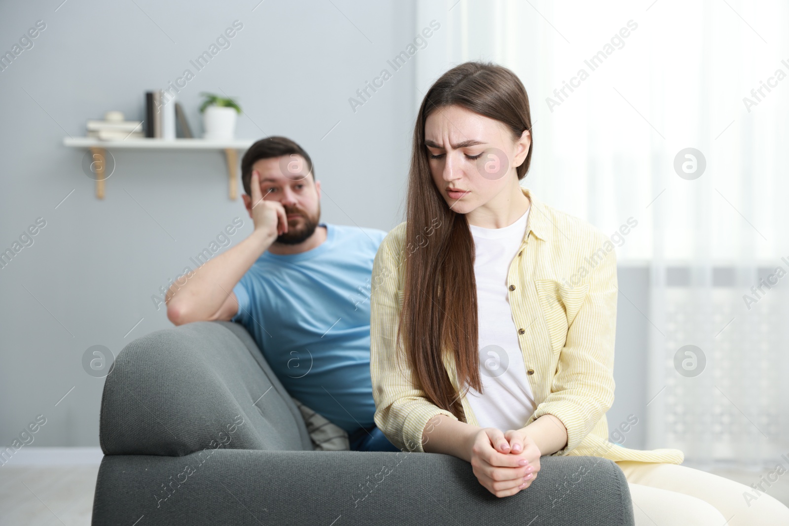 Photo of Resentful couple sitting on couch at home, selective focus