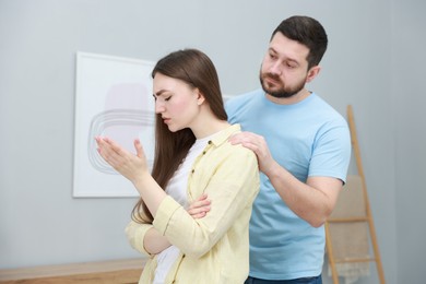 Man comforting his resentful girlfriend at home