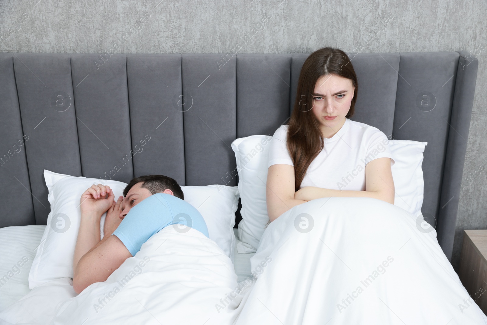 Photo of Resentful couple lying on bed at home