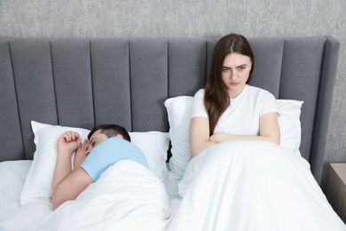 Photo of Resentful couple lying on bed at home