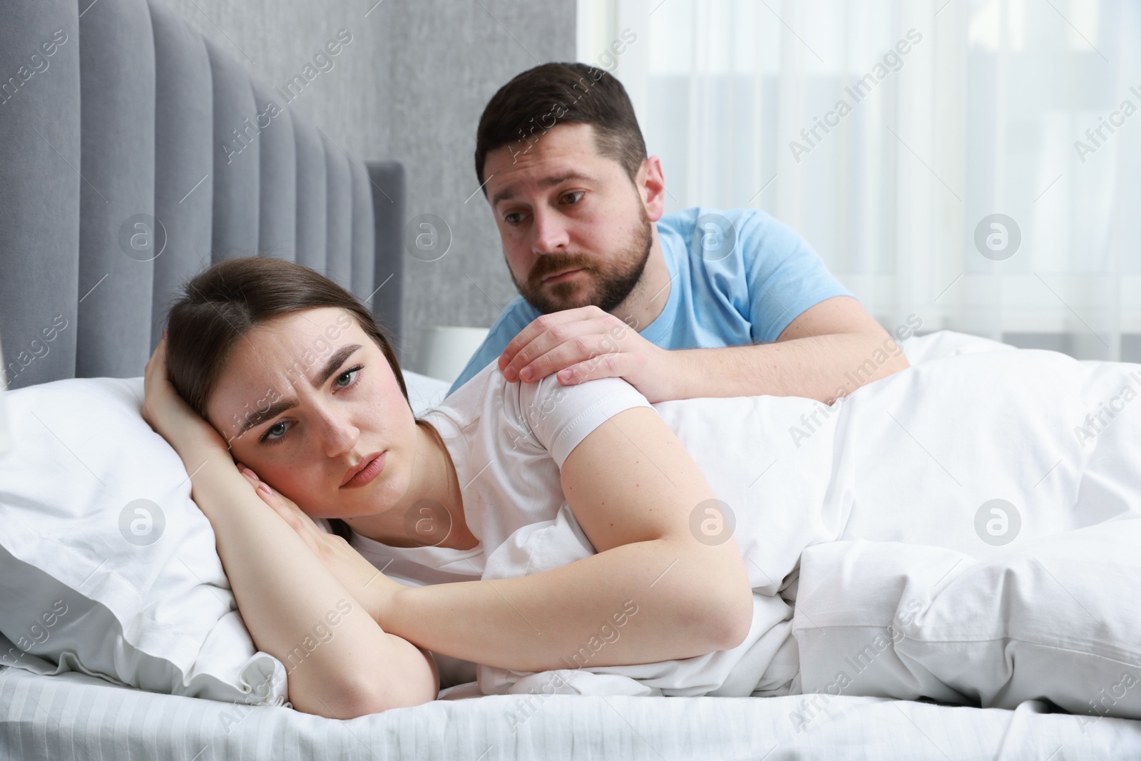 Photo of Man comforting his resentful girlfriend on bed at home