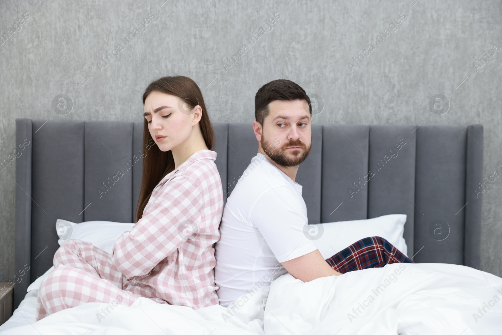 Photo of Resentful couple sitting on bed at home