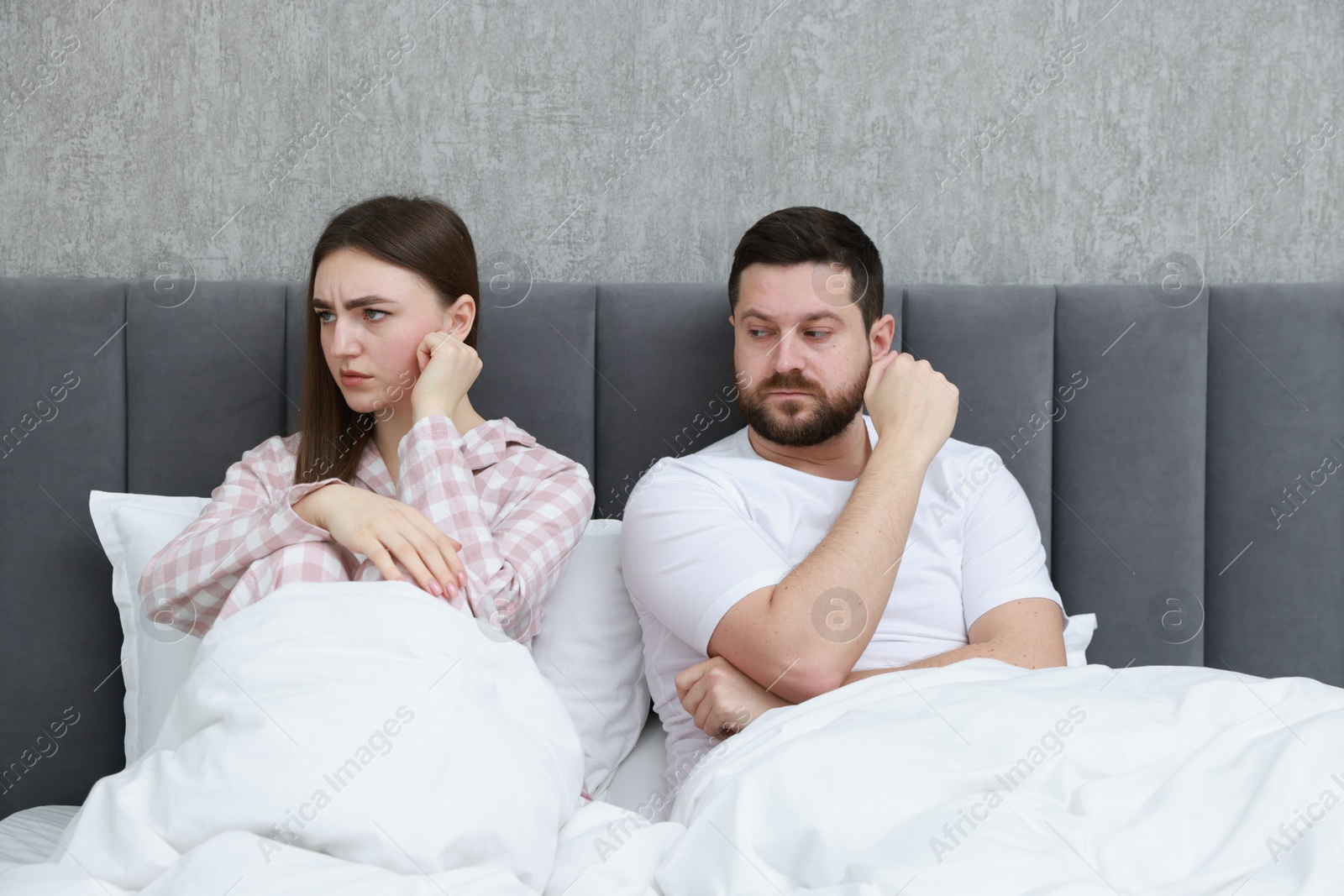 Photo of Resentful couple lying on bed at home