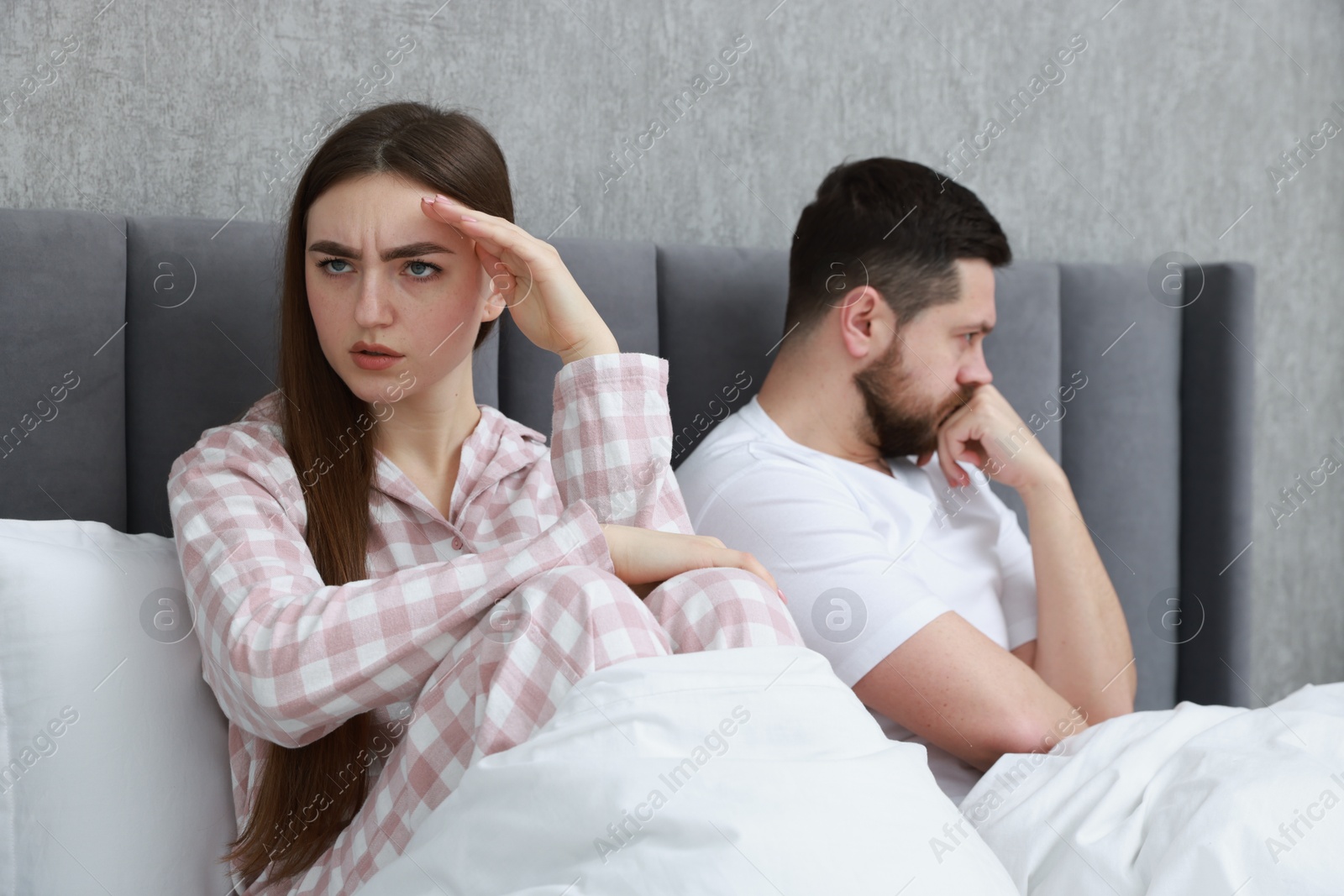 Photo of Resentful couple lying on bed at home