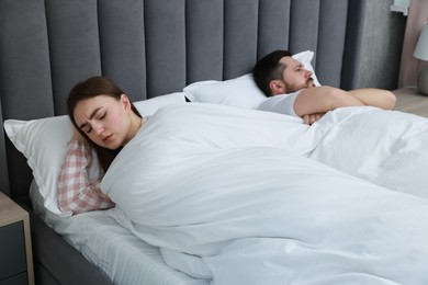 Photo of Resentful couple lying on bed at home, selective focus