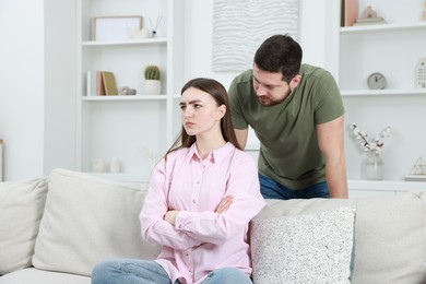 Photo of Man comforting his resentful girlfriend at home. . Relationship problem