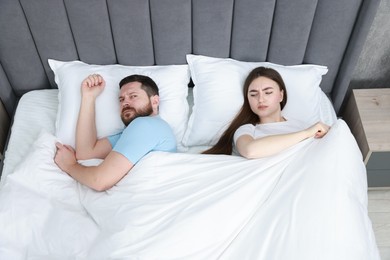 Photo of Resentful couple lying on bed at home, above view