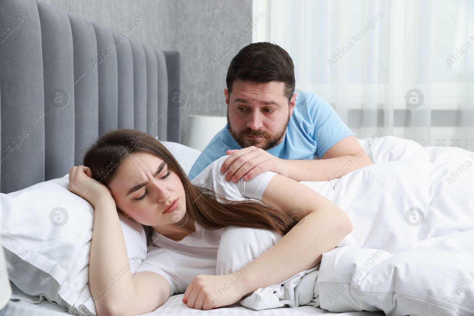 Photo of Man comforting his resentful girlfriend on bed at home