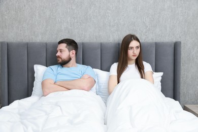 Photo of Resentful couple lying on bed at home, above view