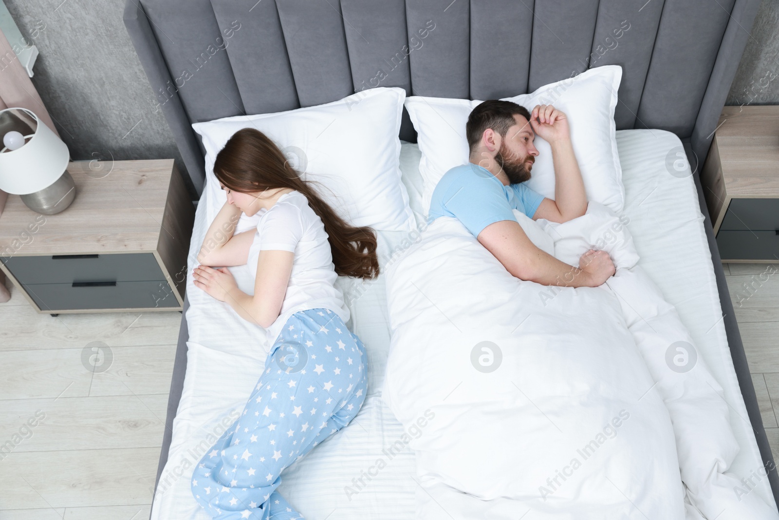 Photo of Resentful couple lying on bed at home, above view