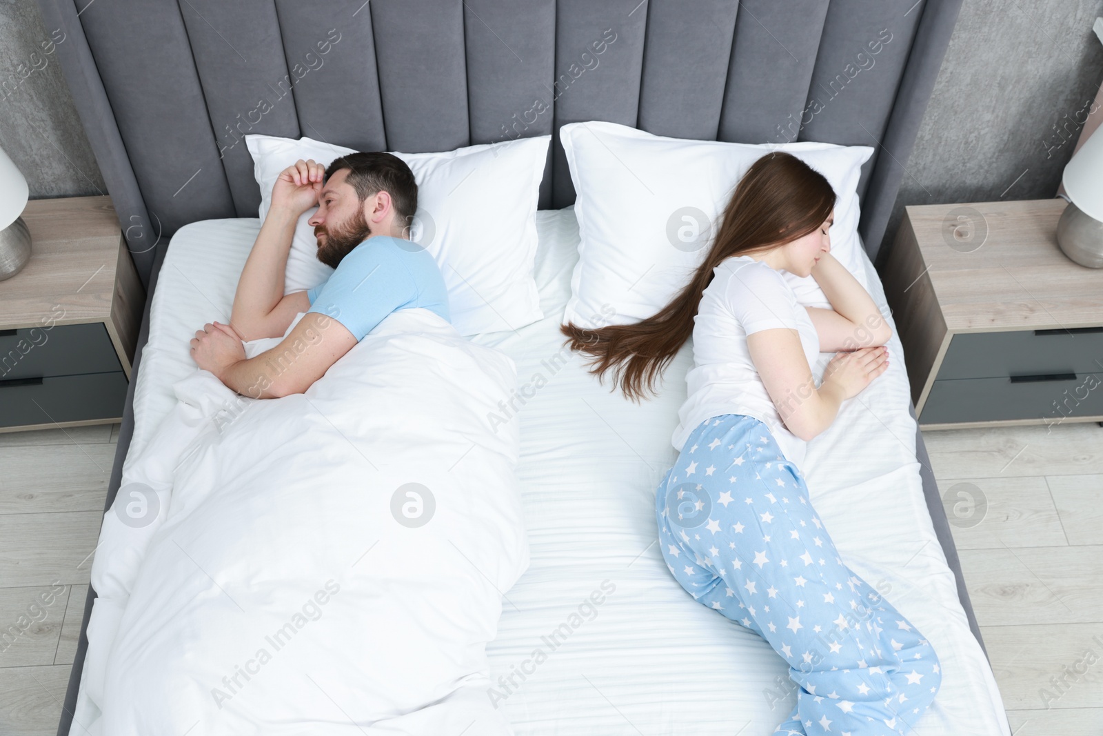 Photo of Resentful couple lying on bed at home, above view