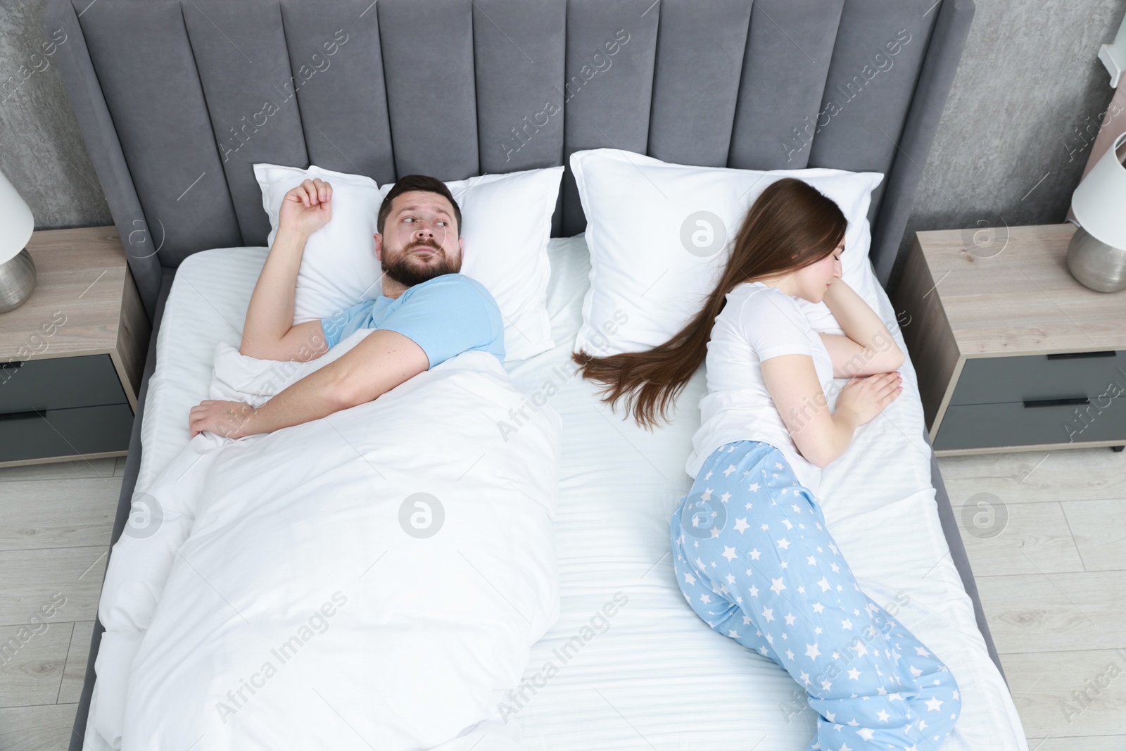 Photo of Resentful couple lying on bed at home, above view