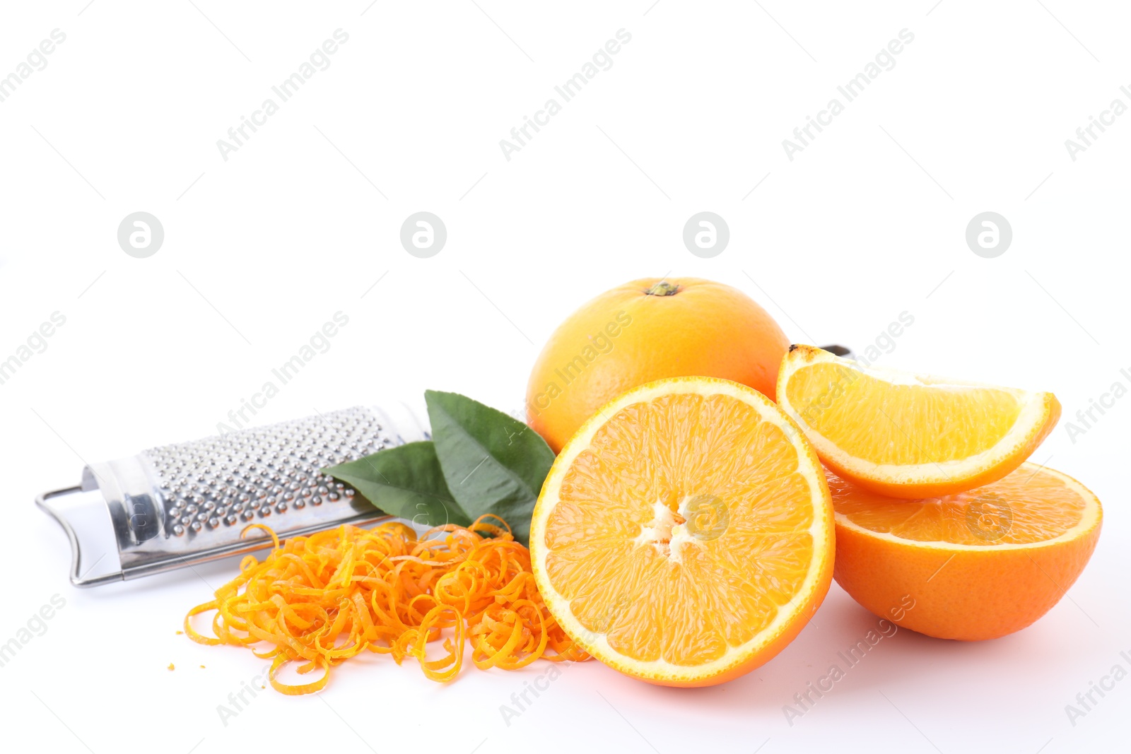 Photo of Pile of fresh orange zest, fruits, leaves and grater isolated on white