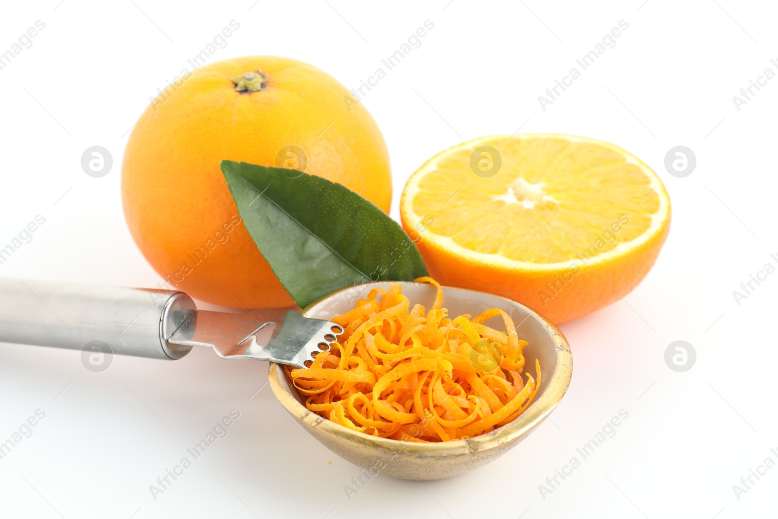 Photo of Fresh orange zest in bowl, fruits and zester on white background