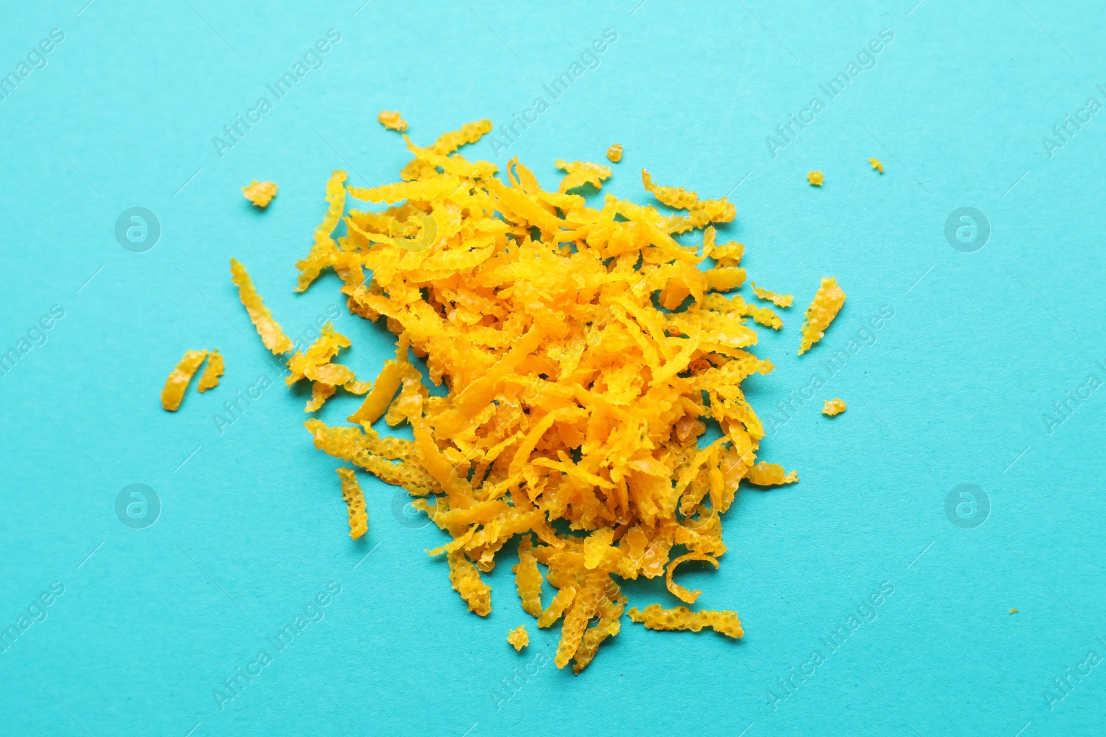 Photo of Pile of fresh orange zest on turquoise background, top view