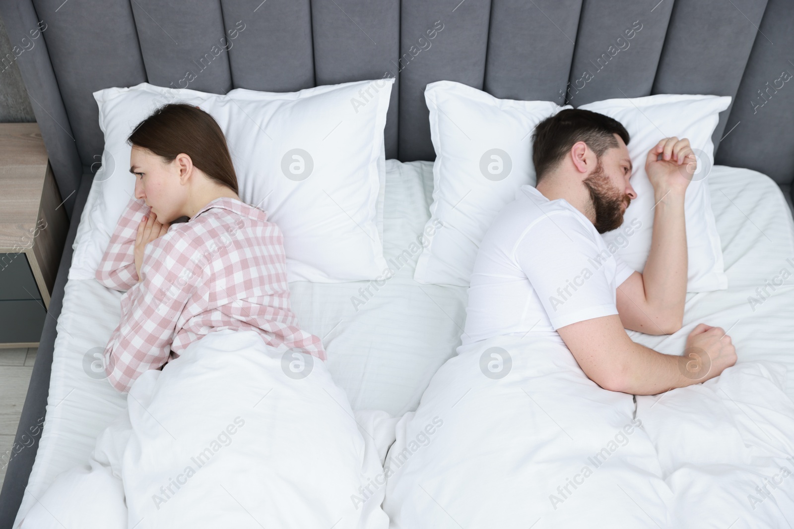 Photo of Resentful couple lying on bed at home, above view