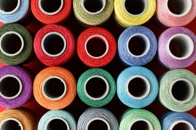 Photo of Different spools of sewing threads on table, top view