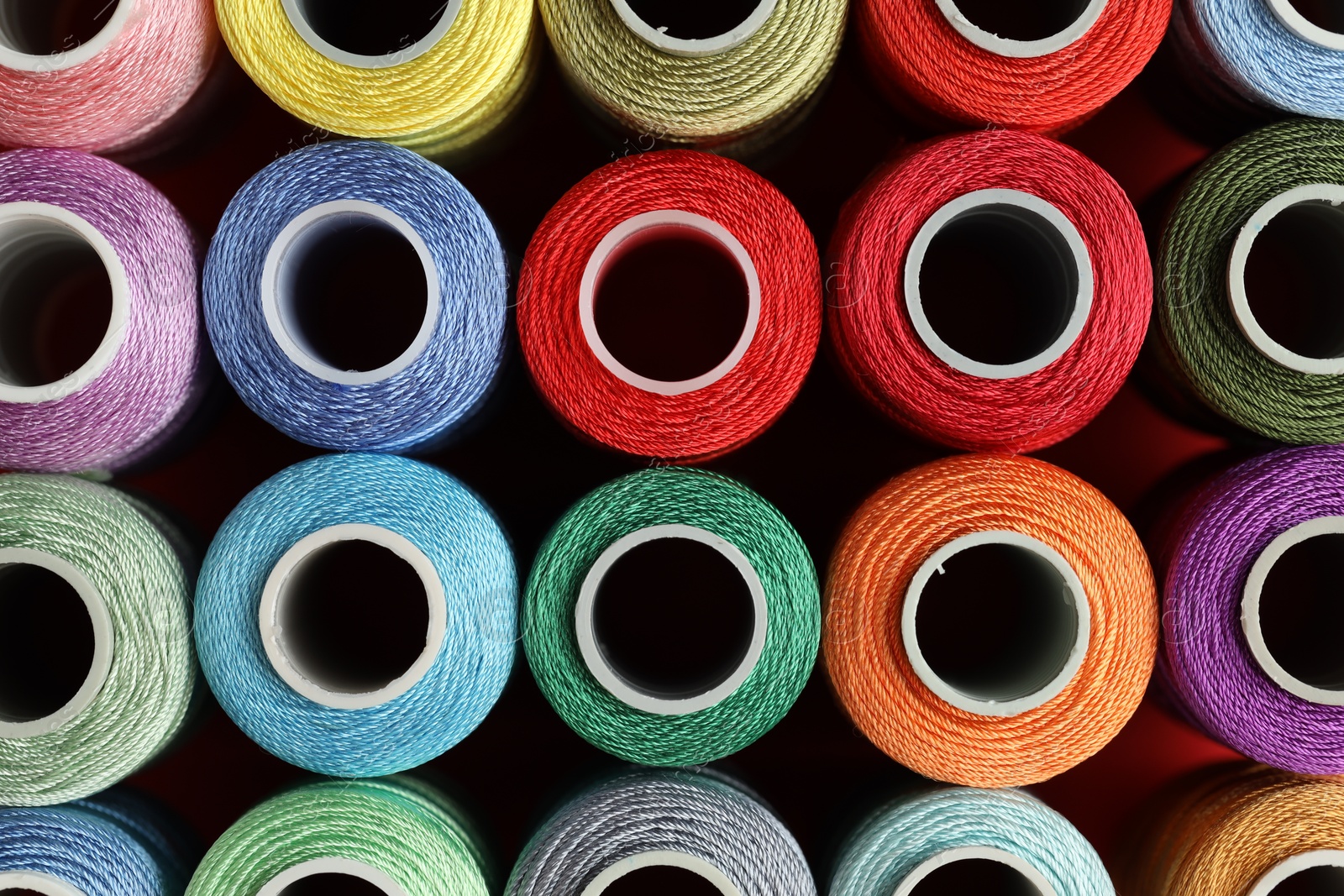 Photo of Different spools of sewing threads on table, top view