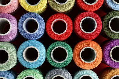 Photo of Different spools of sewing threads on table, top view