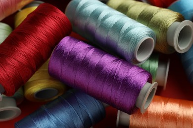 Photo of Different spools of sewing threads as background, closeup