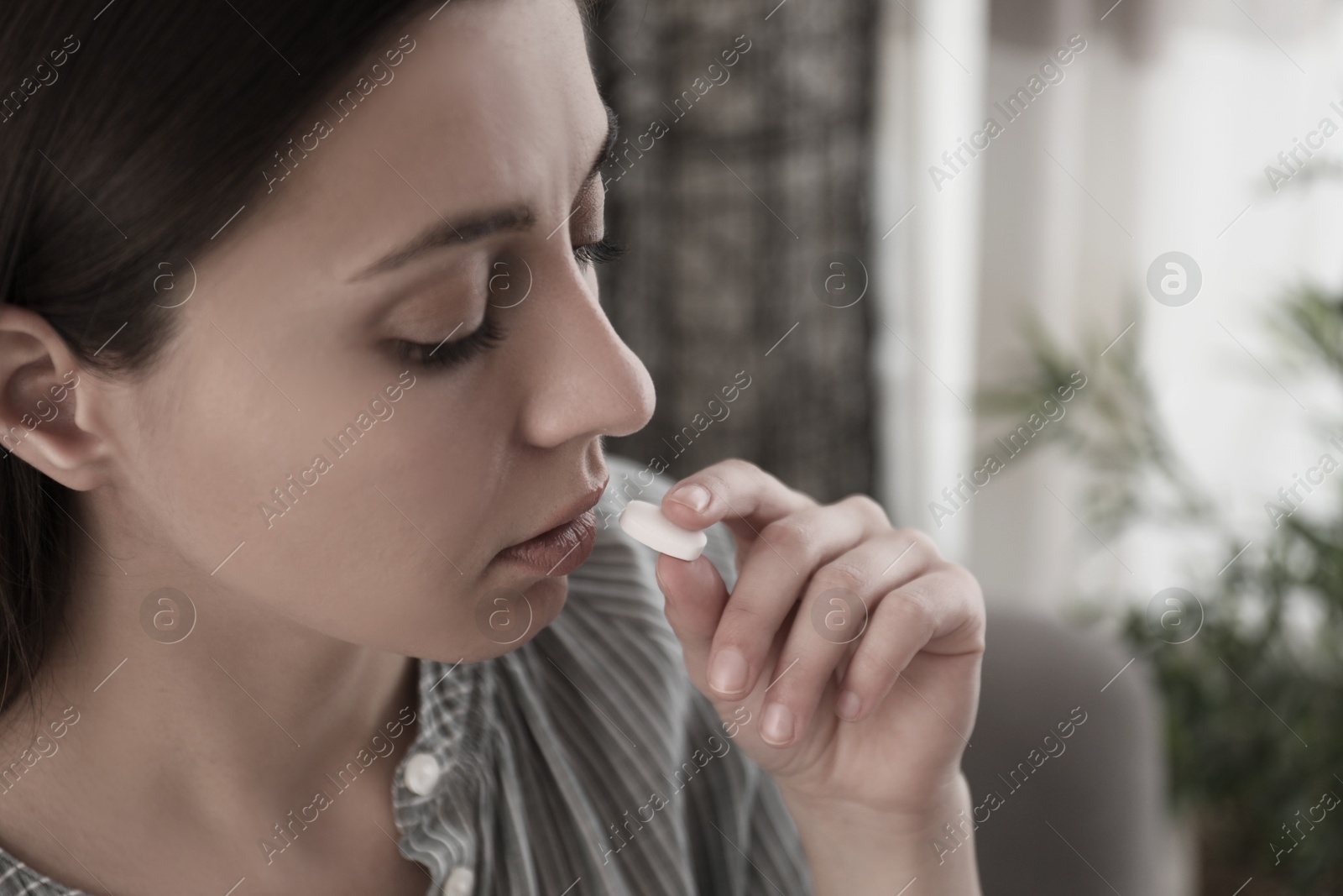 Image of Young woman taking pill indoors, closeup. Toned for dramatic atmosphere