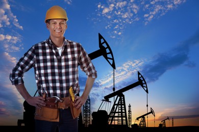 Worker at oil production site with crude oil pumps