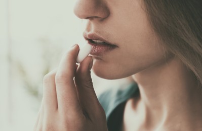 Image of Young woman taking pill indoors, closeup. Toned for dramatic atmosphere