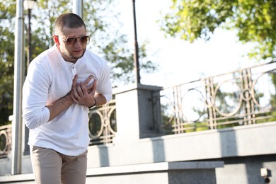 Photo of Man having heart attack on city street