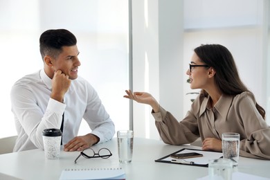 Photo of Office employees talking at table during meeting