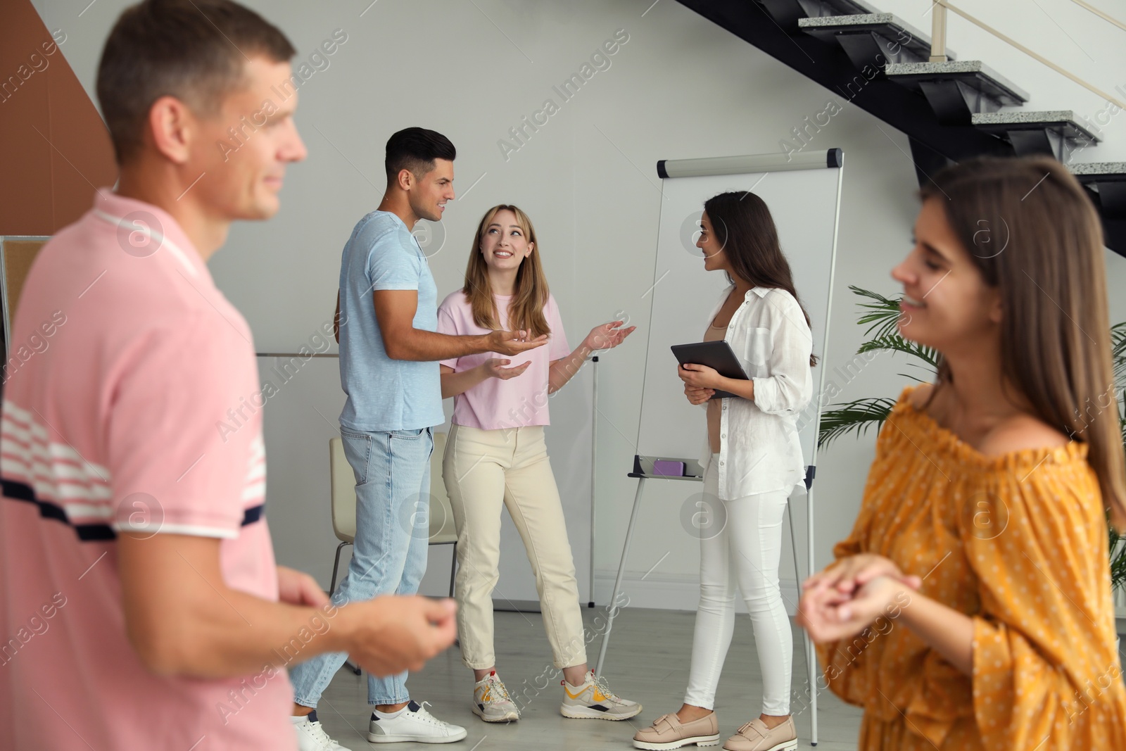 Photo of Group of people talking near whiteboard in hall