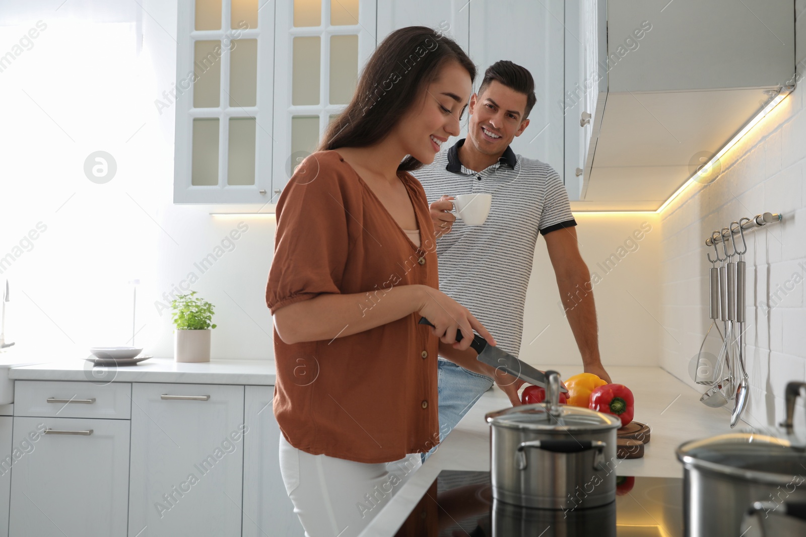 Photo of Man and woman talking while cooking in kitchen