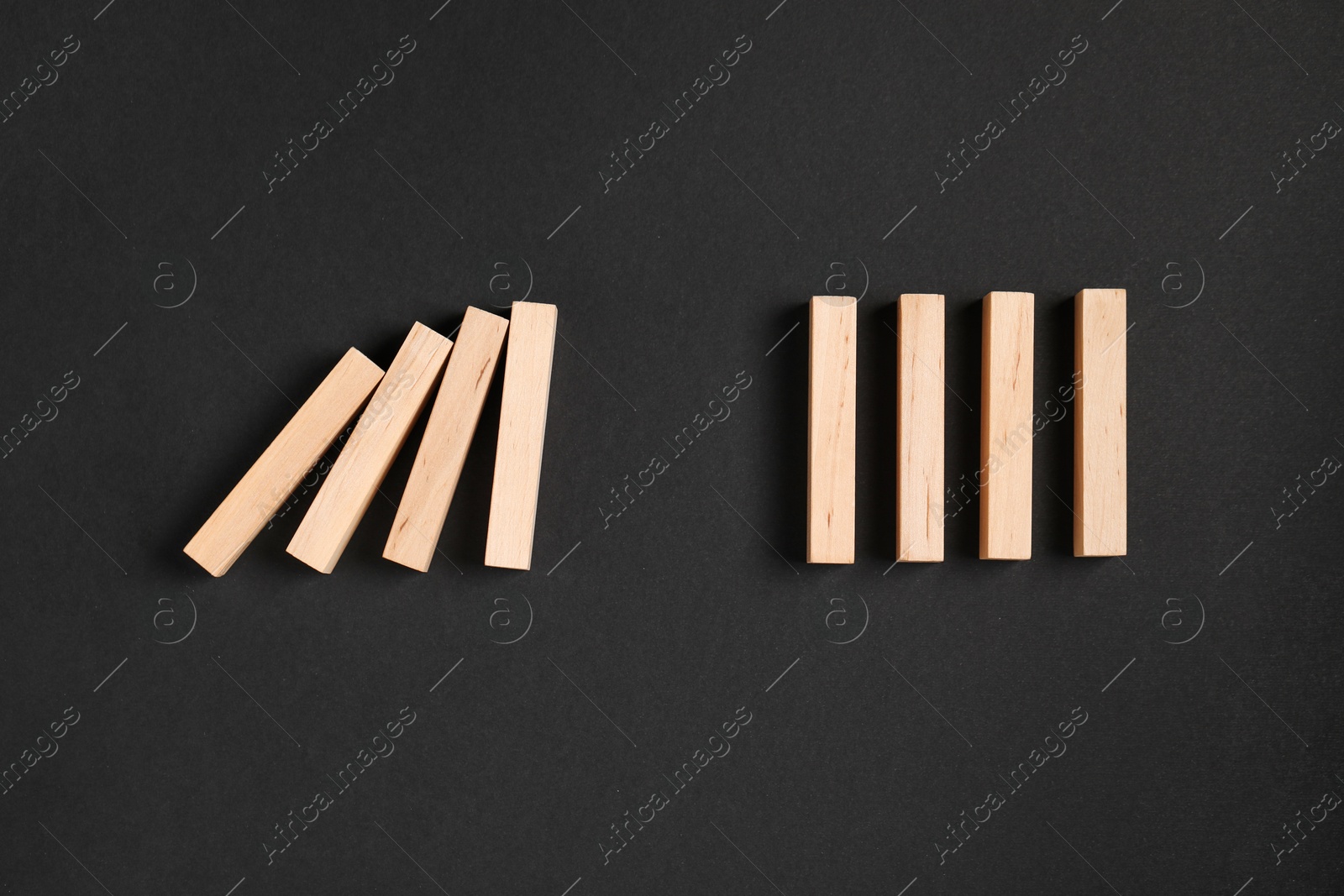 Photo of Domino effect. Wooden blocks on black background, flat lay