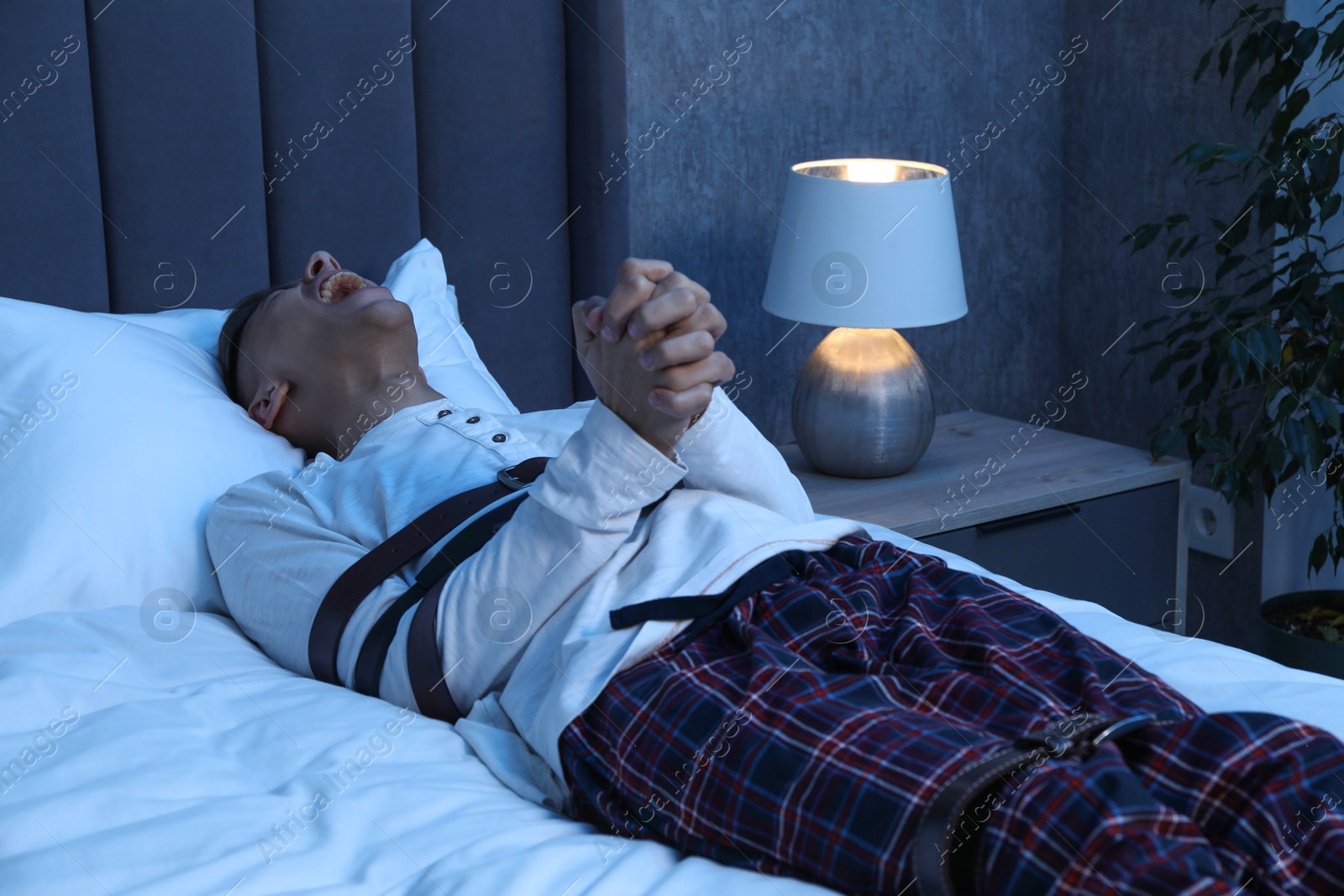 Photo of Man in sleepwalking condition screaming on bed