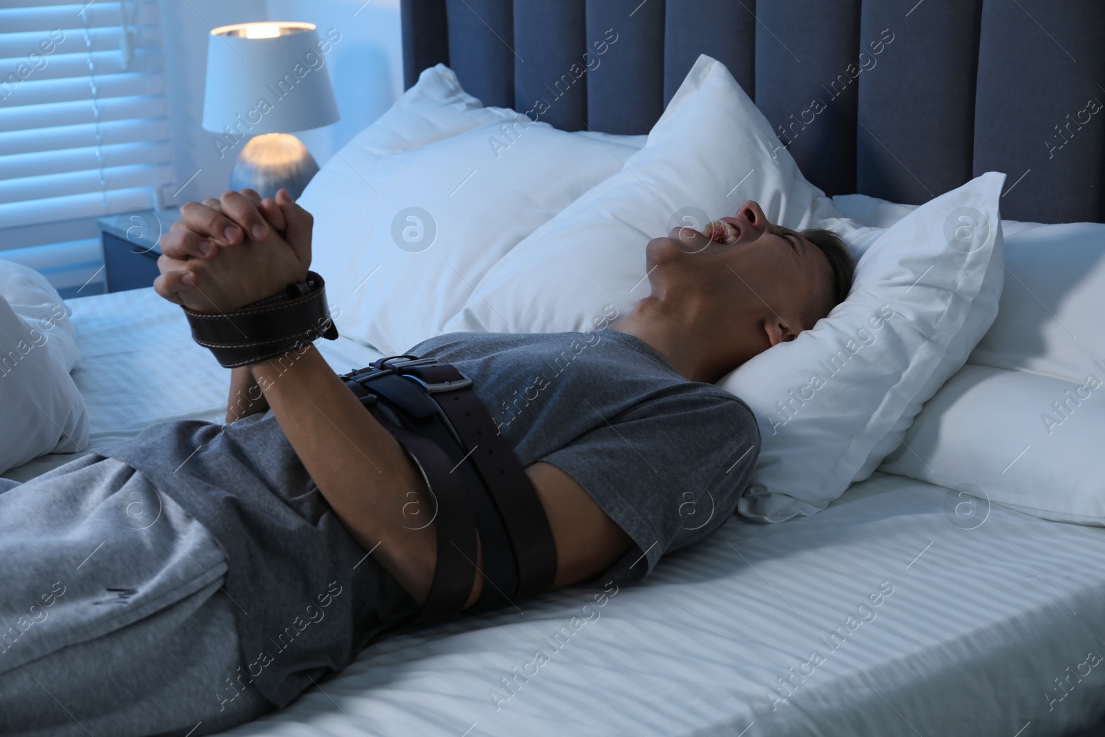 Photo of Man in sleepwalking condition screaming on bed